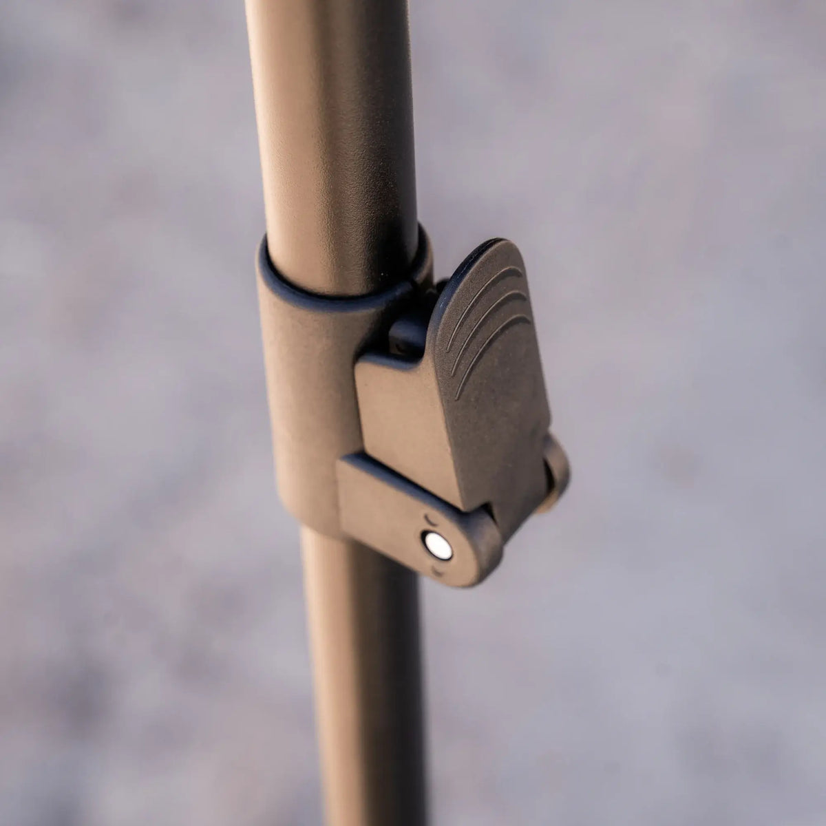 Close-up of a metallic pole featuring a hinged clamp lock mechanism, part of the CVT 180 Degree Awning—engineered to deliver instant shade and reliable outdoor shelter—shown against a softly blurred, neutral background.