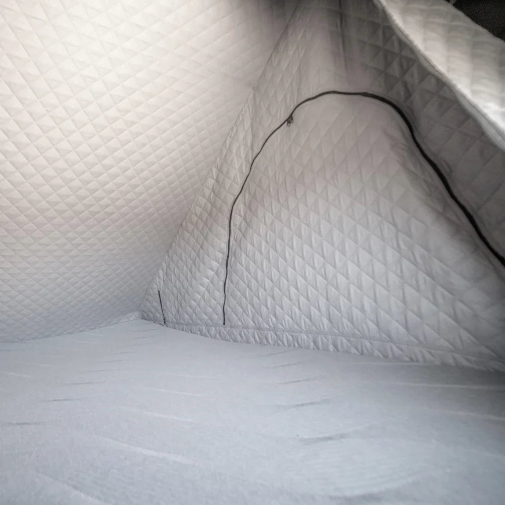 Interior view of a small, gray, quilted pod featuring CVT’s Mt. Hood Insulation Walls with diamond-patterned padded walls and floor and a zippered entrance—ideal for cold-weather camping thanks to its insulated liner designed to boost tent warmth.