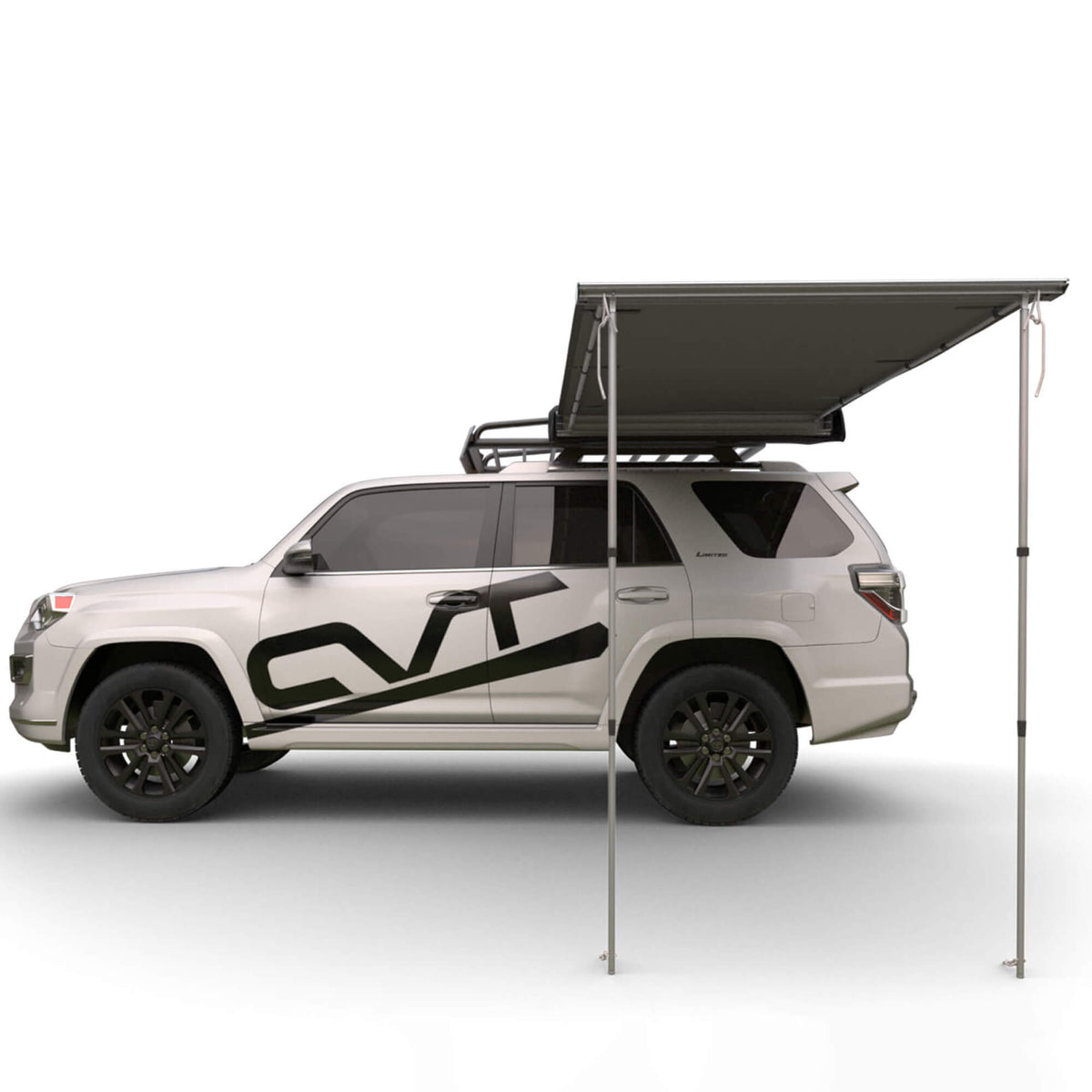 A white SUV with a roof rack and black graphics is parked with a large, rectangular CVT Pioneer Awning - 79″ Medium extended from the roof, supported by two poles, providing versatile outdoor shelter.