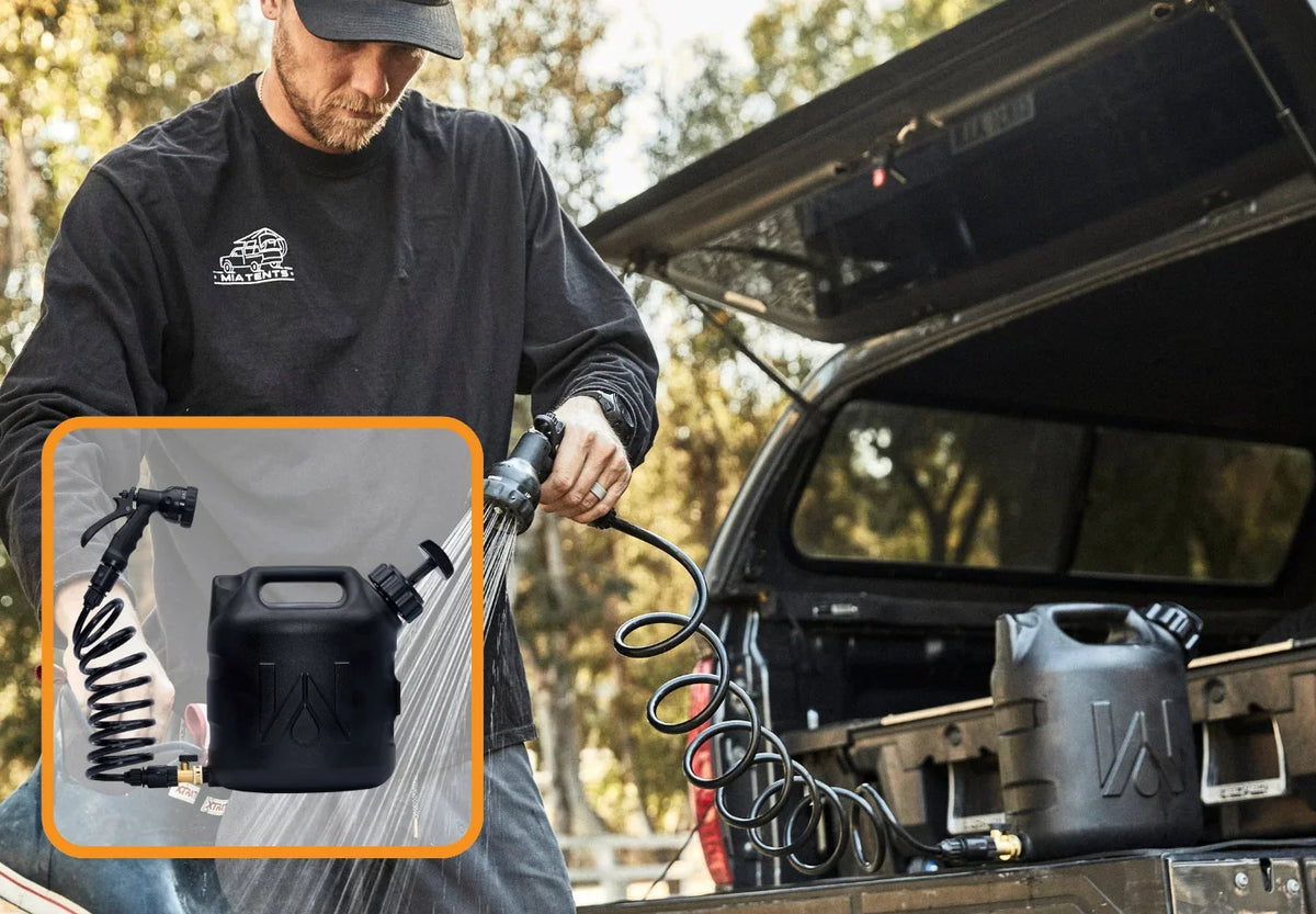 A person uses a portable black water tank with a spray nozzle and coiled hose, attached to a pickup truck. An inset shows the tank, hose, and nozzle in detail. Trees and sunlight are in the background.