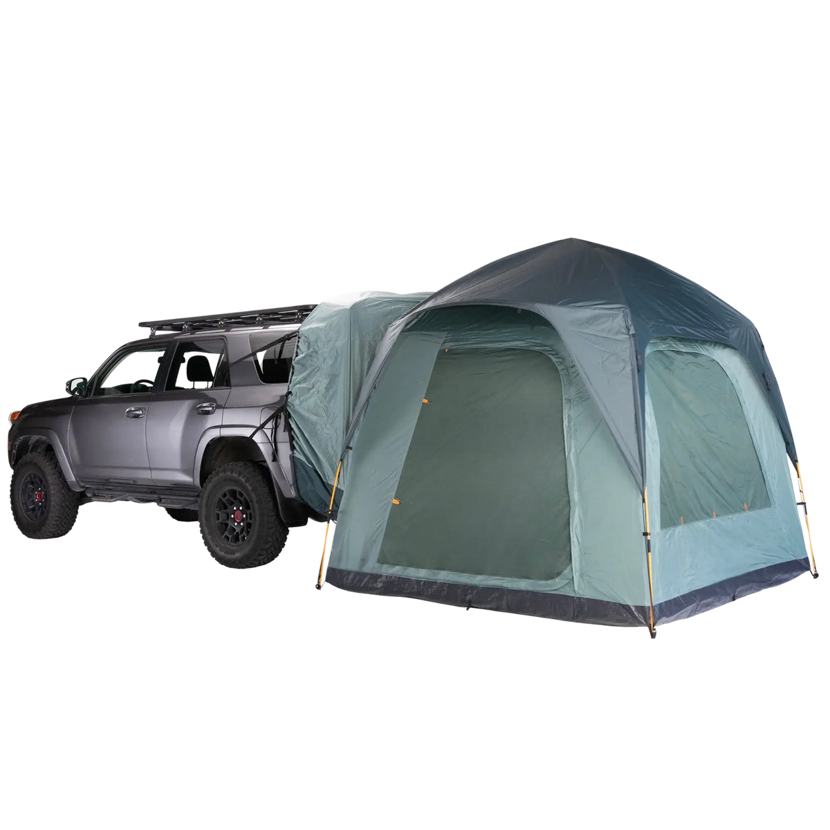 A gray SUV with a roof rack is parked next to a large CVT Timber Creek SUV Tent, which features a dome-style design and attaches directly to the back of the vehicle, creating an integrated camping setup perfect for overlanding.