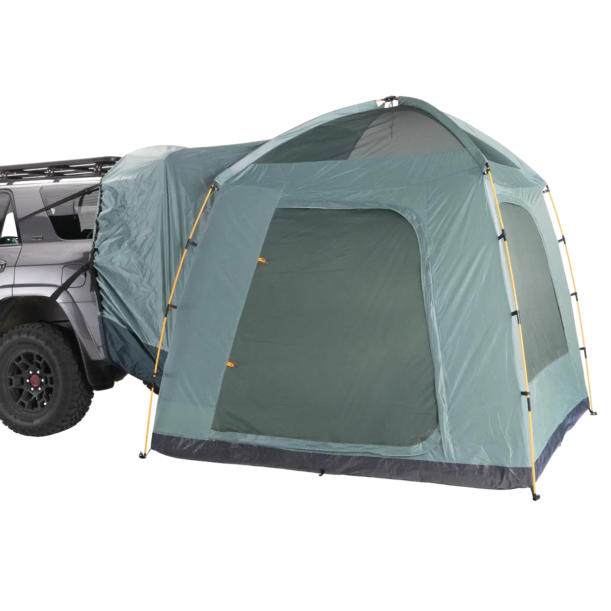 A CVT Timber Creek SUV Tent in green, featuring a dome-style design, is secured to the rear of a gray vehicle—providing an extended, sheltered camping area that offers comfort and convenience for overlanders on their adventures.