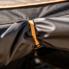 Close-up of a yellow clip securing two pieces of black fabric together—likely part of the CVT 180 Degree Awning—providing instant shade for your outdoor shelter.
