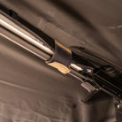Close-up of a fabric strap securing a metal pole to a dark, textured surface, likely part of the CVT 270 Degree Awning.