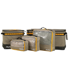 Five CVT Soft Side Storage™ bags in tan and black, featuring yellow trim and clear tops, are displayed in a row on a white background. These water-resistant bags come in assorted sizes to conveniently organize your travel essentials.