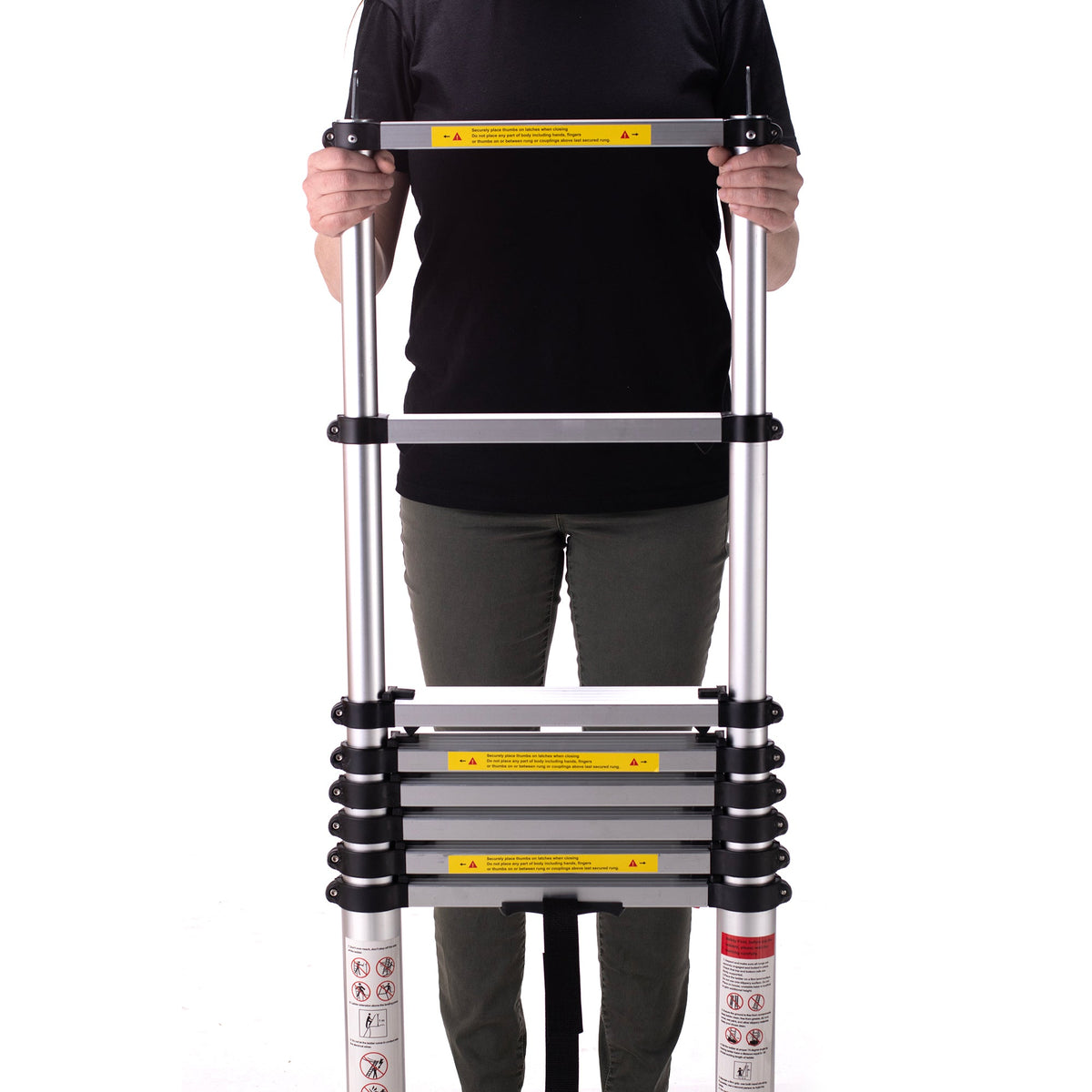 A person in a black shirt and green pants holds a compact, silver CVT Pioneer Ladder vertically against a white background.