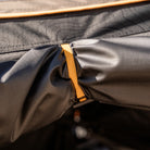 Close-up of a yellow strap securing black fabric on the CVT 270 Degree Awning Wall, featuring visible texture and reinforced stitching on weather-protective material.