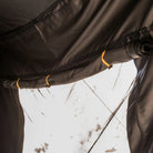 Close-up of a tent’s black fabric window rolled up and secured with yellow straps, allowing bright sunlight to stream in—perfect for pairing with the CVT 270 Degree Awning Wall to boost your weather protection.