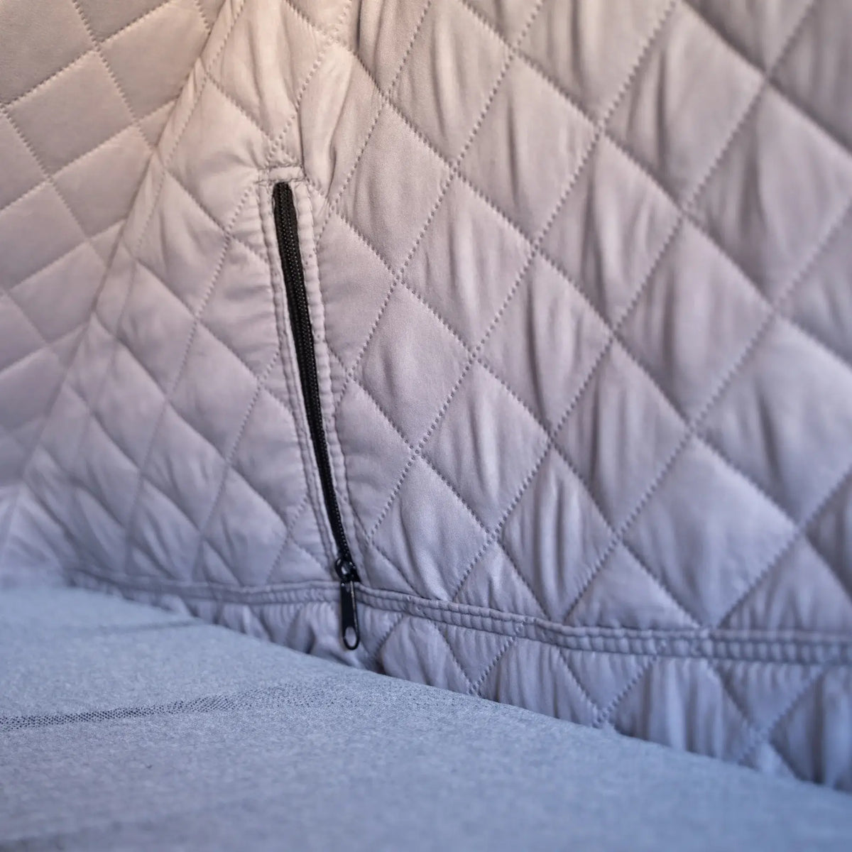 Close-up of the CVT Mt. Hood Insulation Walls, showcasing quilted light gray fabric with diamond stitching and a black zipper. The padded material serves as an insulated liner, designed to enhance tent warmth during cold-weather camping.
