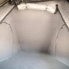 The photo displays the interior of a CVT Mt. Hood Insulation Walls shelter, featuring a gray, quilted design with zippered side panels and a diamond-patterned insulated liner engineered to maximize warmth during cold-weather camping.
