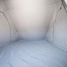 Interior view of a tent featuring the CVT Mt. Hood Insulation Walls, with quilted, silver-gray panels and an insulated floor that create a cozy, padded environment—perfect for maintaining warmth during cold-weather camping. The photo highlights the spacious interior and textured finish provided by the Mt. Hood Insulation Walls, with no objects or people inside to showcase the liner’s design and comfort.