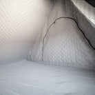 Interior view of a small, gray, quilted pod featuring CVT’s Mt. Hood Insulation Walls with diamond-patterned padded walls and floor and a zippered entrance—ideal for cold-weather camping thanks to its insulated liner designed to boost tent warmth.