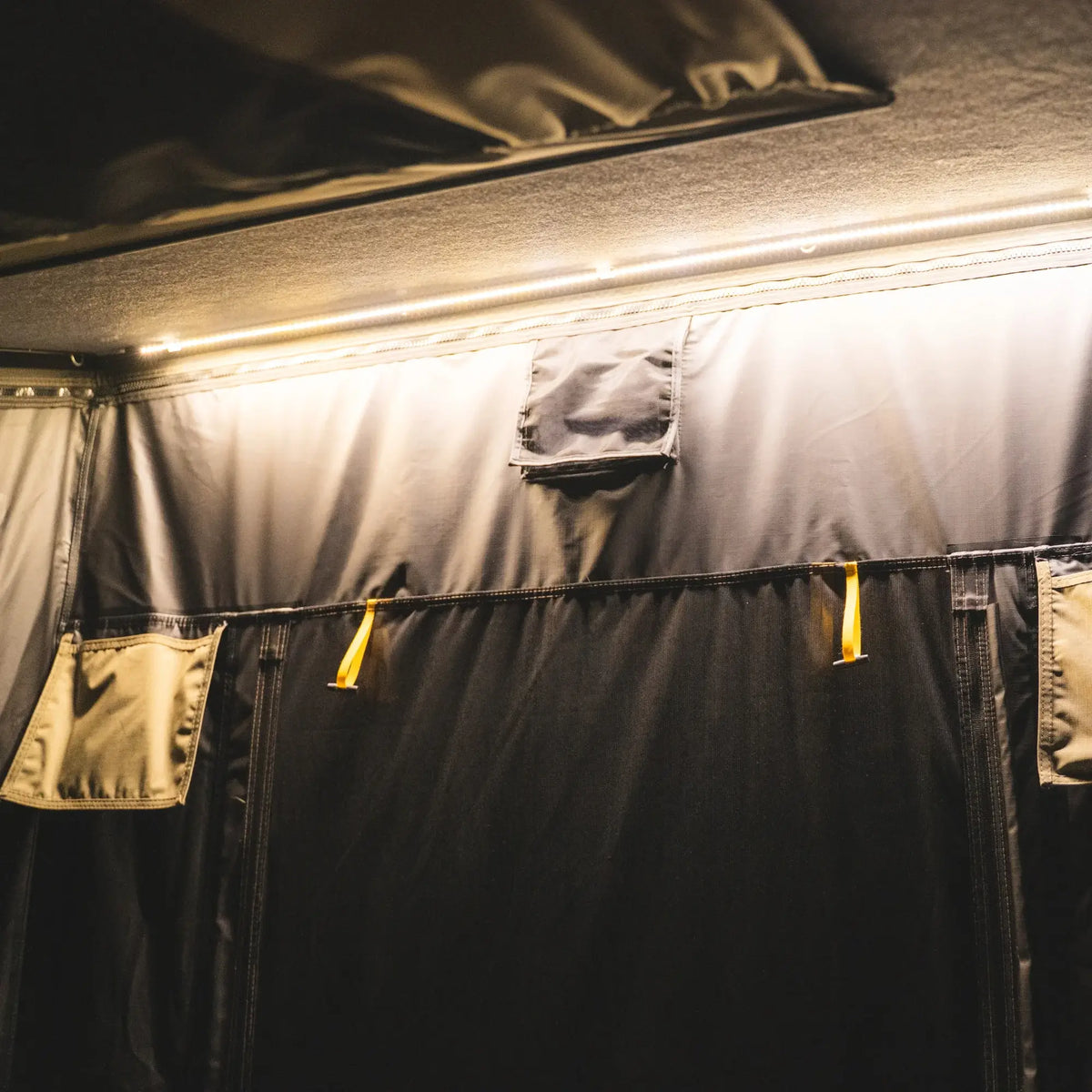 Interior view of the CVT Mt. Hood 2 Hardshell Tent, featuring durable fabric walls, zippered panels, mesh windows, and warm yellow ambient ceiling lighting—perfect for your next outdoor adventure.