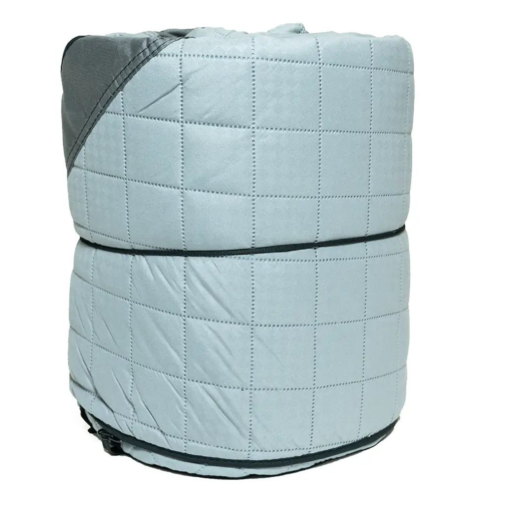 A light gray quilted comforter is rolled up tightly, with a darker gray corner partly visible on top—perfect for cold weather camping or adding extra warmth to CVT’s Pioneer Insulation Walls thanks to their excellent insulation.