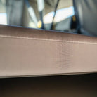 Close-up of a beige fabric edge with visible stitching on the CVT Pioneer Mattress Cover, highlighting its quality construction against a blurred background.