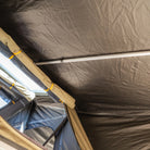 Interior view of the CVT Pioneer 2 Softshell Tent roof with sturdy metal support poles and rolled-up fabric near a window, highlighting the thoughtful construction and ample natural light—an ideal setup for overland adventures.