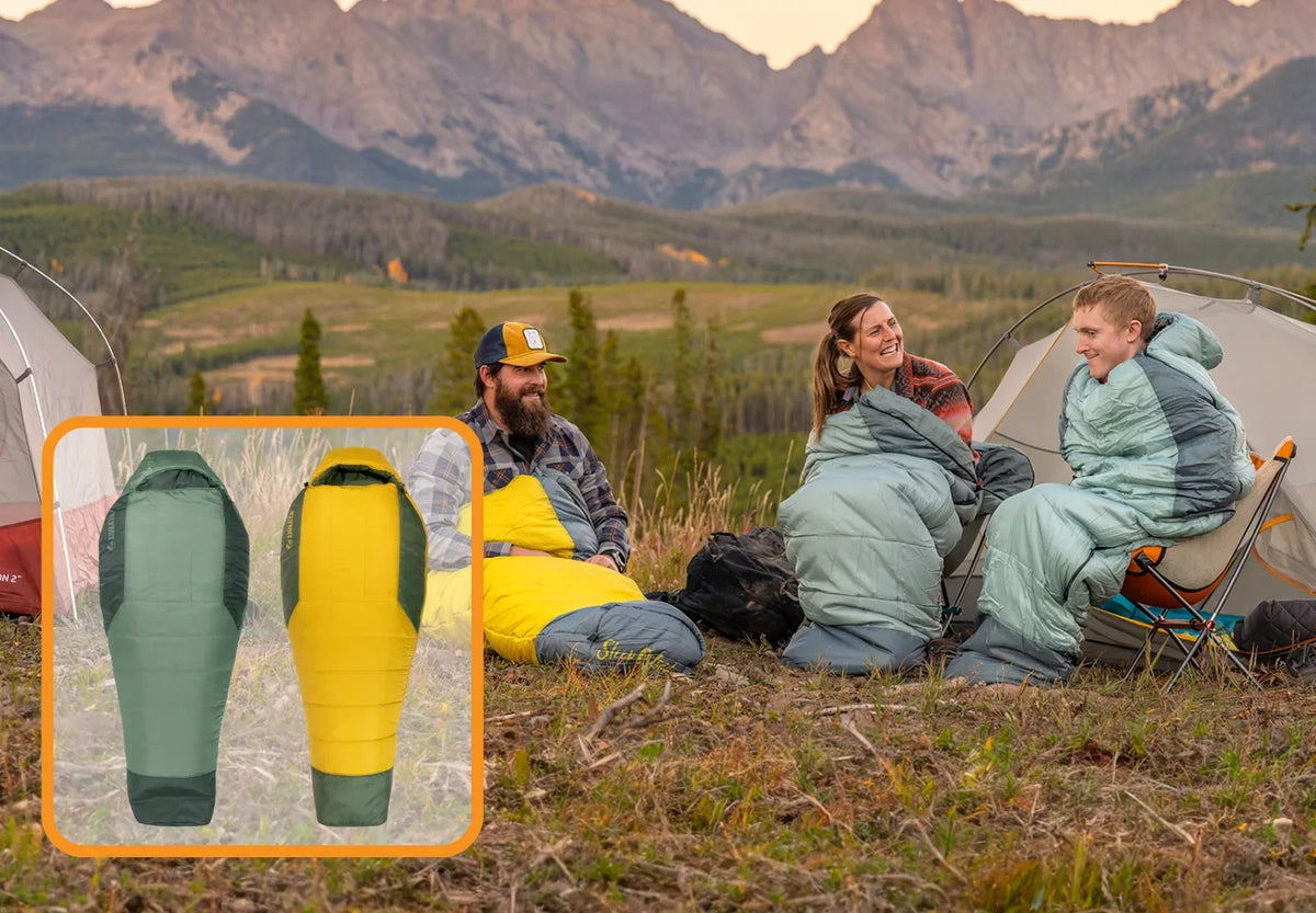 Three people in sleeping bags sit by tents in a grassy field with mountains in the background. An inset shows two sleeping bags—one green and gray, one yellow and gray—displayed vertically for comparison.