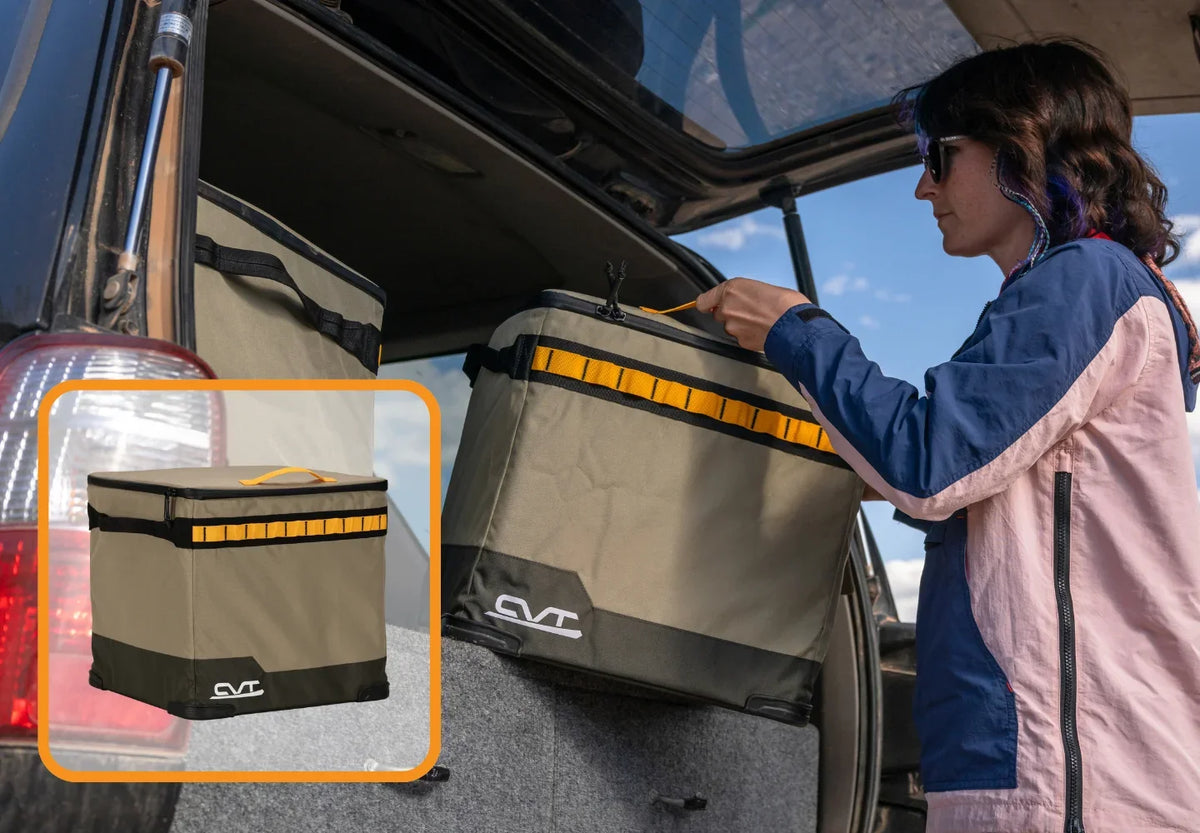 A person places a collapsible tan and black storage bin with a yellow stripe in the back of an SUV. An inset shows a close-up of the closed bin.