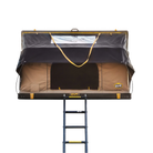 CVT La Sal Tent Fabric roof-top tent with an open canvas door, attached ladder, and protective rain cover, viewed from the front. The tent features a brown and black design with yellow accents on the frame and ladder.