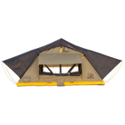 A yellow and gray CVT Pioneer 2 Softshell Tent with mesh windows is set up on a flat surface, featuring the CVT logo on the lower right corner—perfect for overland adventures.